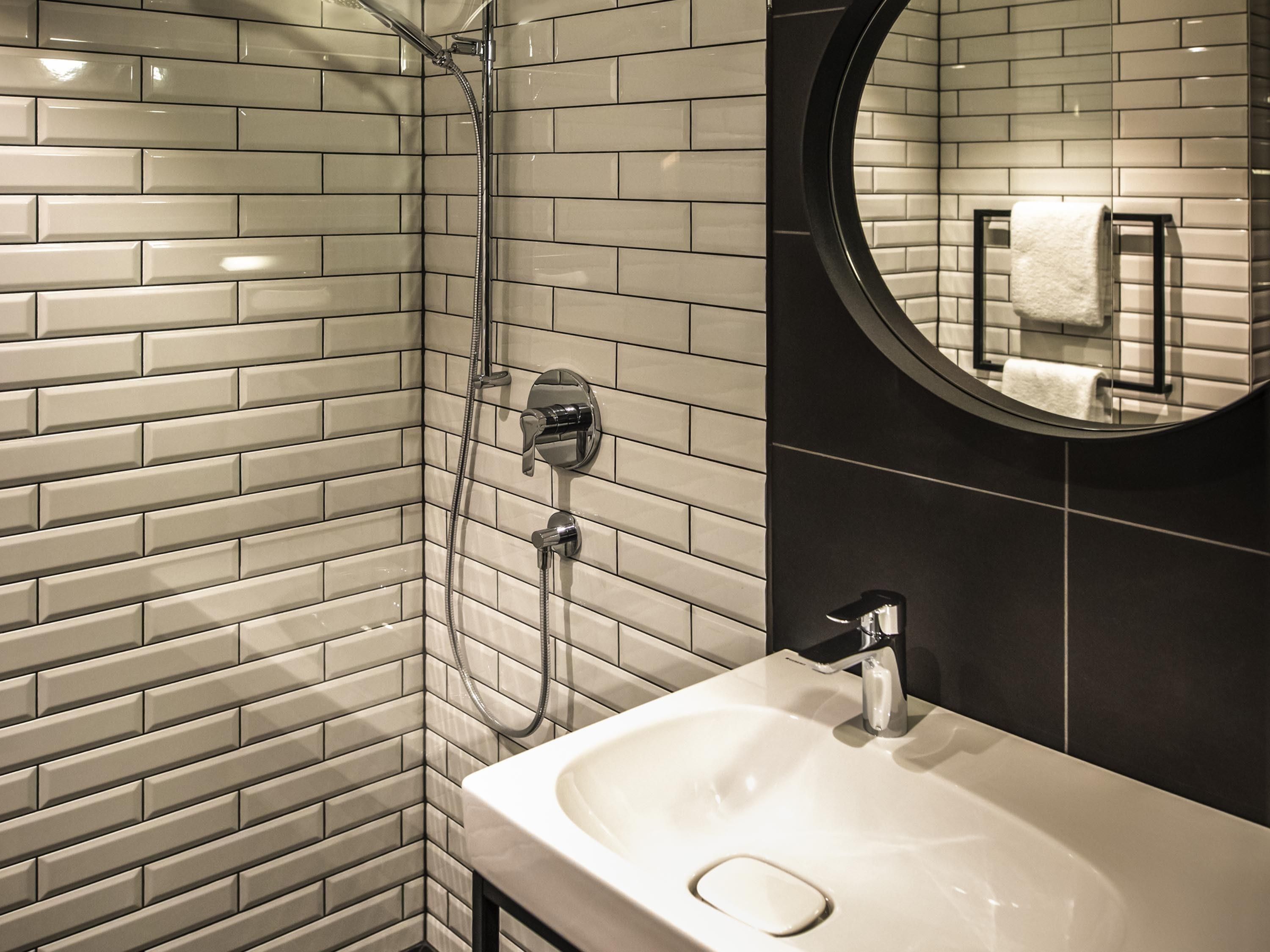 A bathroom with a shower, a sink, and a mirror.
