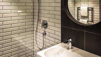 Ein Badezimmer mit Dusche, Waschbecken und Spiegel.