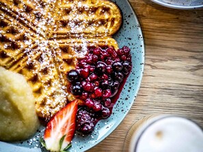 A plate with waffles, berries, and a strawberry. - Ibis Wels (Wels)