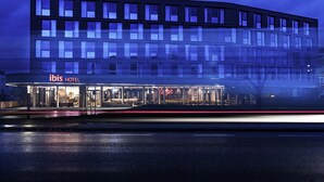 A modern hotel with a glass facade, a visible entrance, and a sign reading 'ibis HOTEL'. - Ibis Wels (Wels)