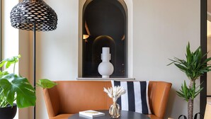 A modern living room with a leather sofa, a round table, a potted plant, and a unique black lamp. - Mercure Luxembourg off Kirchberg (Luxembourg City)