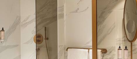 A bathroom with a shower, a mirror, and a sink.