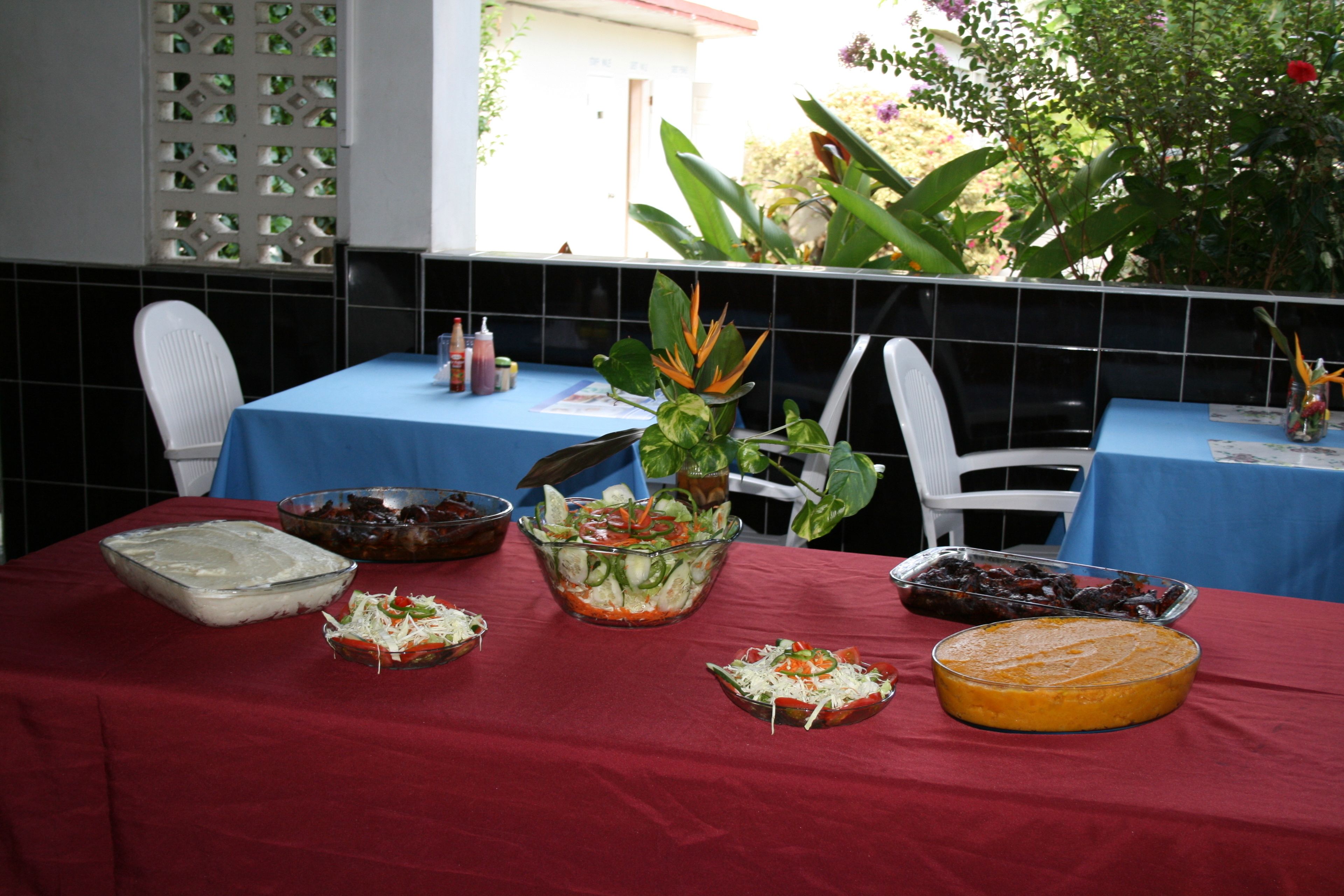A dining table with various dishes, a plant, and a blue tablecloth.