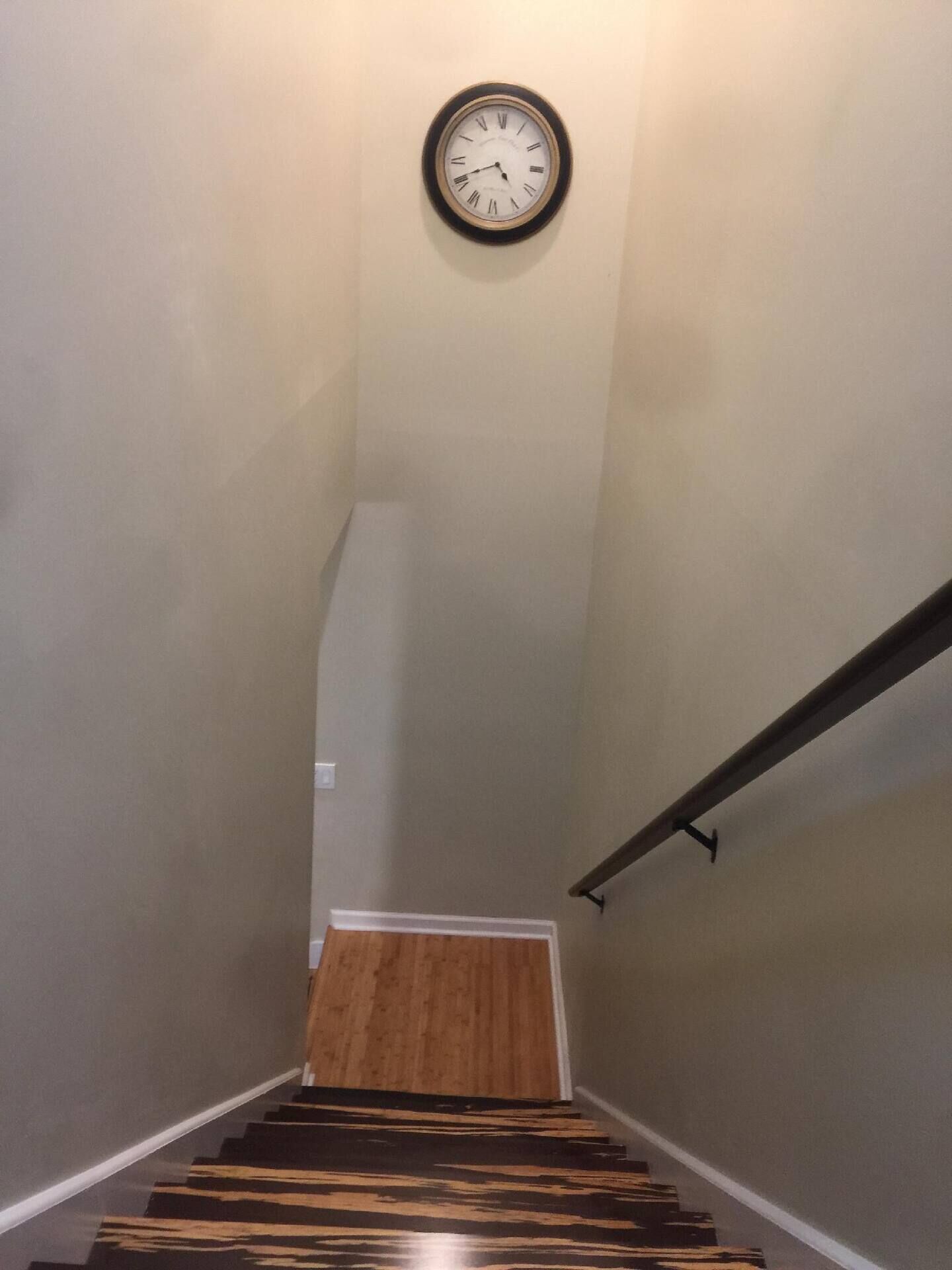 Una escalera con piso de madera y un reloj en la pared.