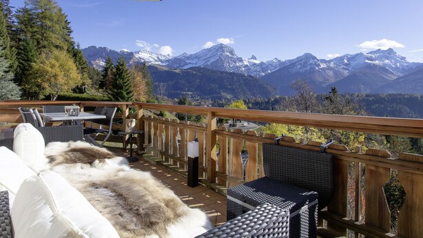 A deck with outdoor furniture overlooking a mountainous landscape. - Villars Bristol Apartments (Ollon)