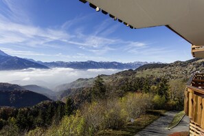 A mountain view with a wooden deck and a clear sky.
