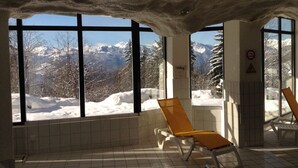 A room with large windows overlooking a snowy mountain landscape. - Villars Bristol Apartments (Ollon)
