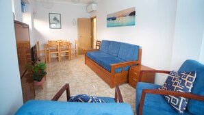 A compact living space with a bed, a sofa, a dining table with chairs, and a small kitchenette. - Meriteluna Sky Sintra (Sintra)