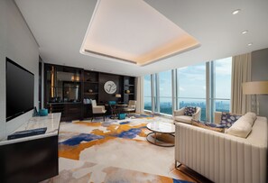 Ein modernes Wohnzimmer mit großem Fernseher, Sitzgelegenheit und Blick auf die Stadt.