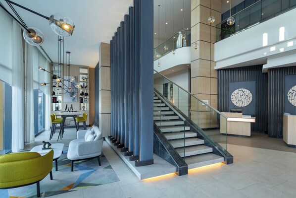 Un intérieur moderne comprenant un escalier, un coin salon et un comptoir d’accueil.