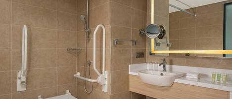 A modern bathroom with a walk-in shower, a sink, and a vanity.