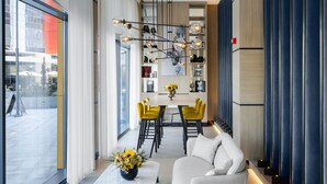 Un interior moderno con comedor, sofá y un amplio ventanal.