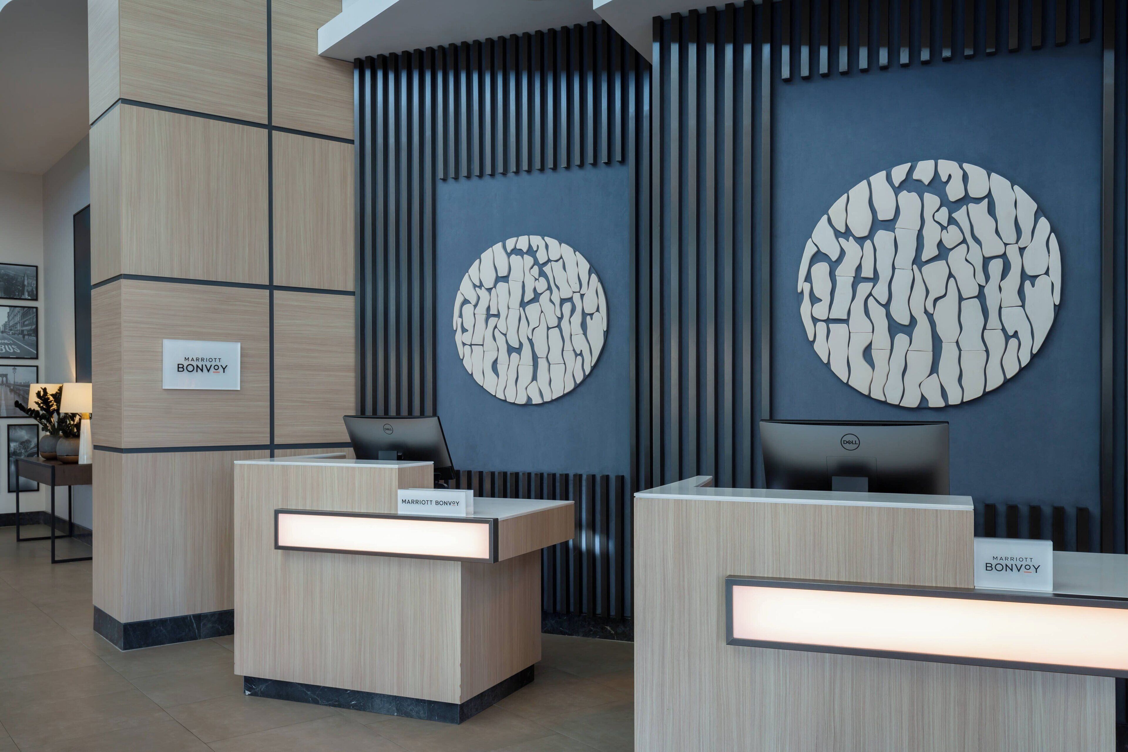 A modern hotel reception area with two reception desks, each labeled 'Marriott Bonvoy'.