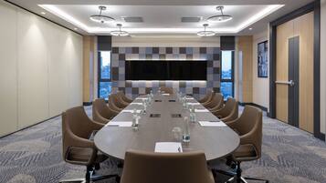 A conference room with a long table, chairs, and a large window.