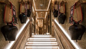 Un magnifique escalier avec des marches en bois poli et un luminaire moderne au sommet.