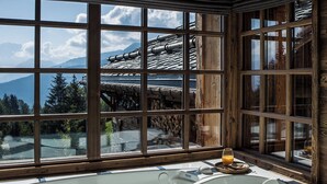 Une cabane en bois dotée d’une grande fenêtre et d’une baignoire.
