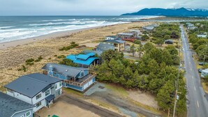 A coastal residential area with houses, a road, and a beach.
