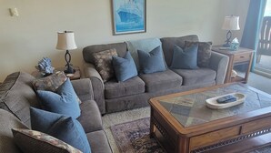 A living room with a sofa, a coffee table, and a lamp.