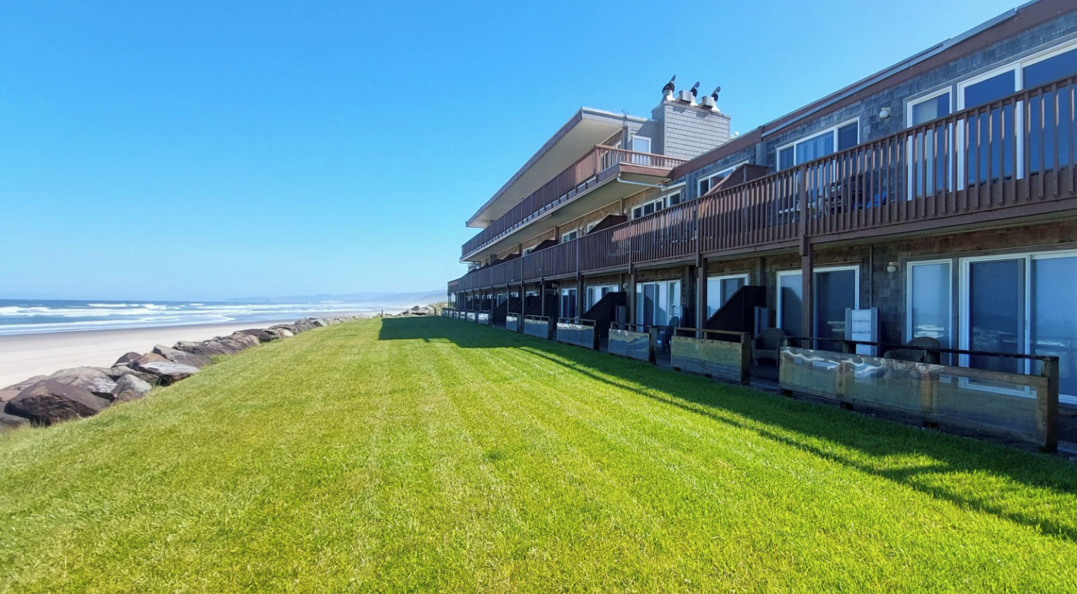 Un hôtel situé en bord de mer, doté d’une pelouse verdoyante, de nombreux balcons et d’une vue sur l’océan.