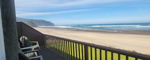 A balcony with a view of a beach and ocean.