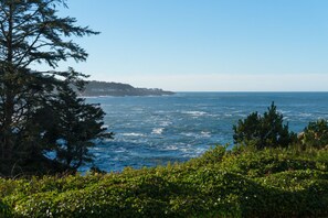 A coastal landscape with a view of the ocean and a distant shoreline with buildings.