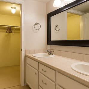 A bathroom with two sinks, a large mirror, and a towel rack.