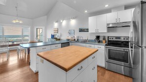 Una cocina moderna con armarios blancos, electrodomésticos de acero inoxidable y una isla de madera.