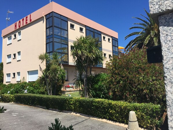 A modern hotel building with a large glass facade, a flat roof, and a sign reading "HOTEL" on the side. - Hotel Florida (Sanxenxo)