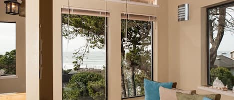 Una habitación con ventanas amplias, un banco y vistas al mar.