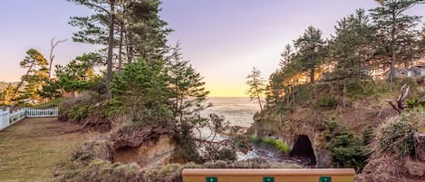 A bench overlooking a coastal landscape with trees and a view of the sea.