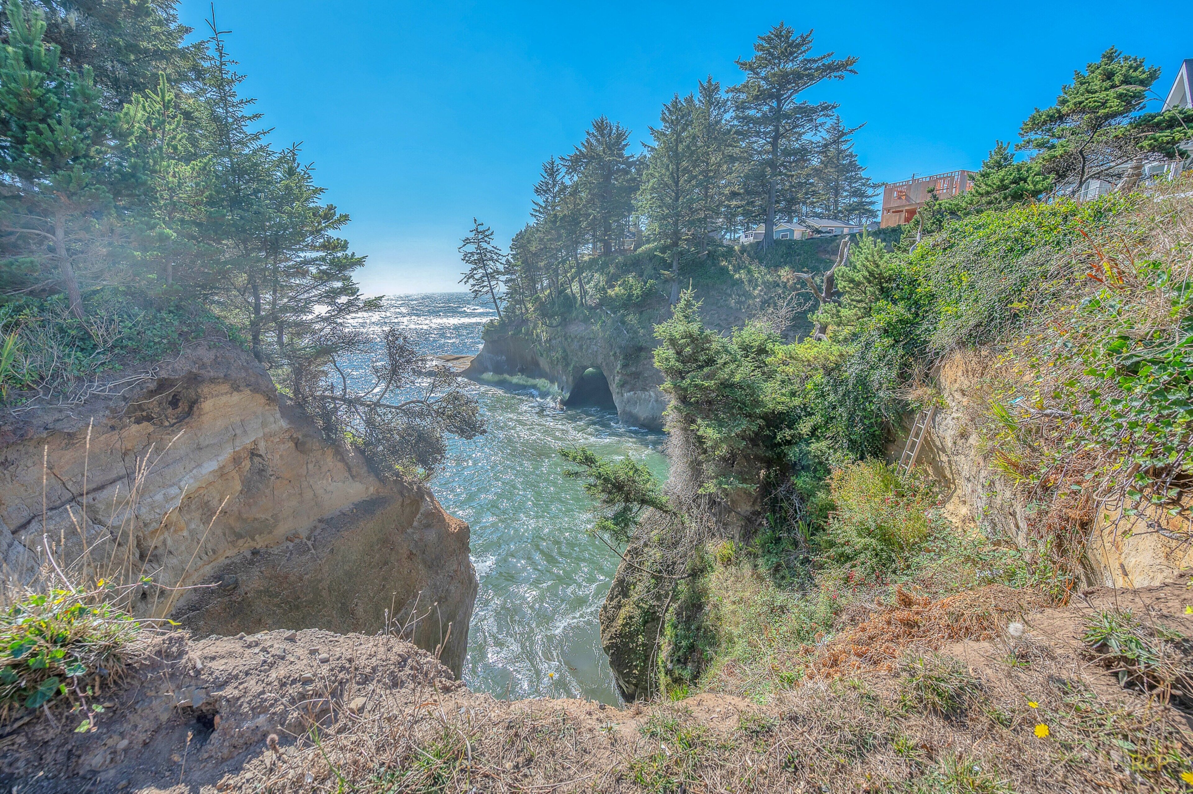 A natural landscape with a river, rocky cliffs, and dense greenery.