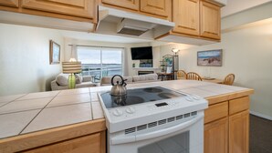 A kitchen with wooden cabinets, a built-in stove, and a dining area with a table and chairs.