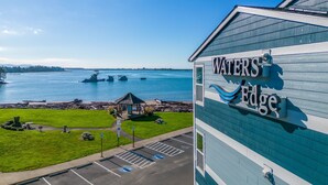 A building with a sign reading "WATERS EDGE" overlooking a body of water.