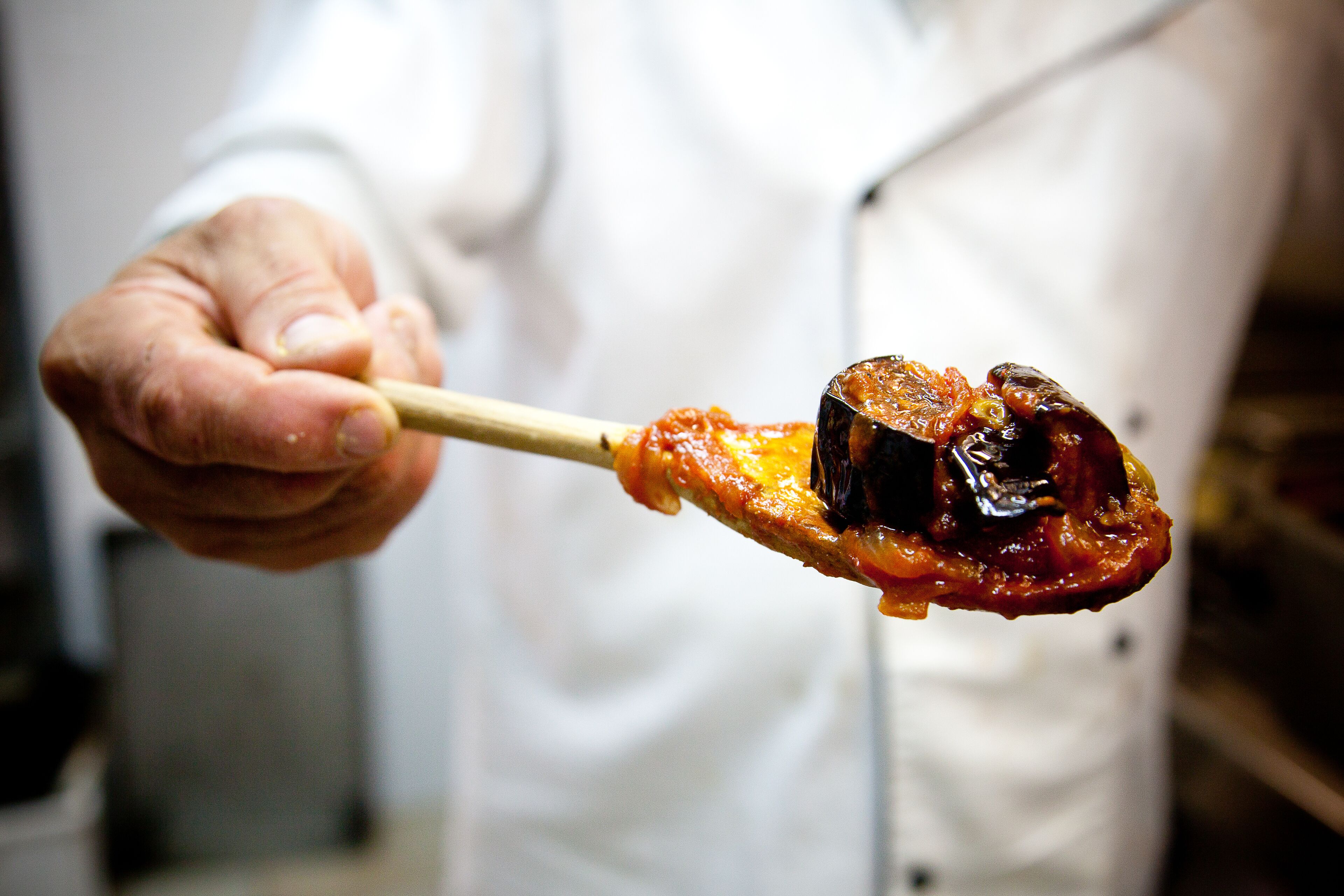 Une personne tenant une brochette avec un aliment grillé.