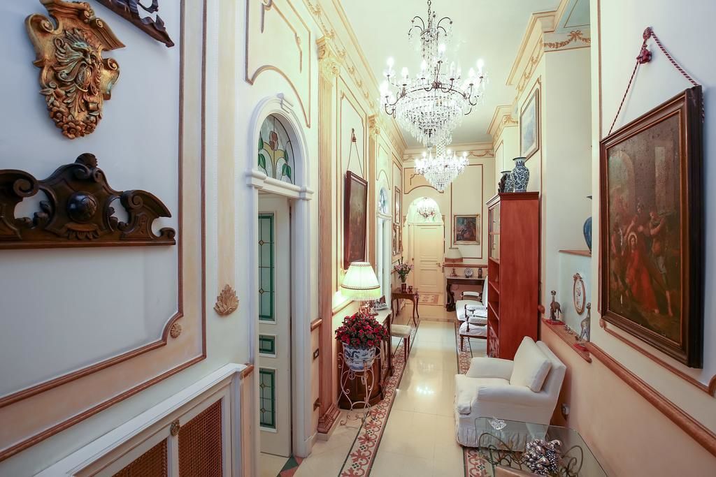 Ein Flur mit aufwendiger Wandgestaltung, einem Chandelier und einem Essbereich mit Tisch und Stühlen.