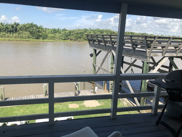 Una terraza de madera con vistas a un río y un bosque.