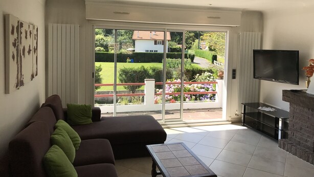 Ein Wohnzimmer mit einer Couch, einem Couchtisch, einem Fernseher und einem Kamin.