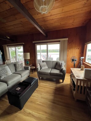 A cozy living room with two sofas, a coffee table, and a wooden floor.