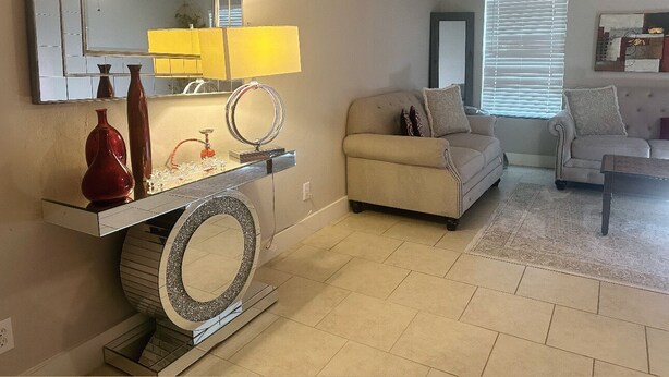 A living room with a sofa, a coffee table, a TV, and a fireplace. - Charming home in sugarland (Sugar Land)