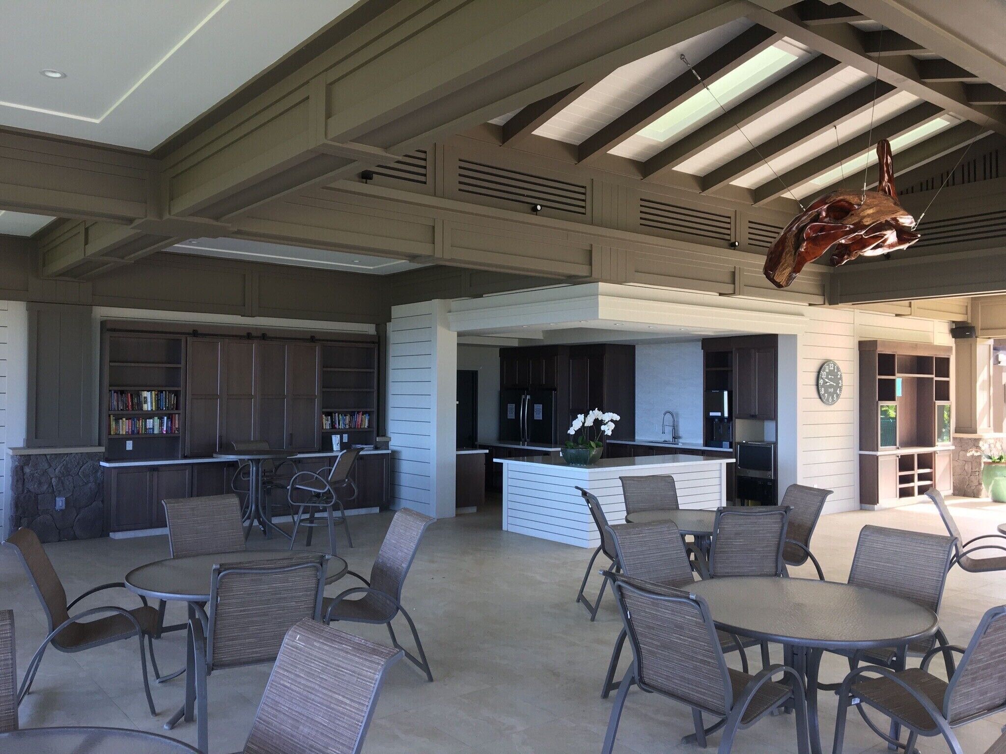 A spacious indoor area with a kitchen, dining area, and bookshelves.
