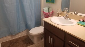 A bathroom with a toilet, sink, and cabinet.