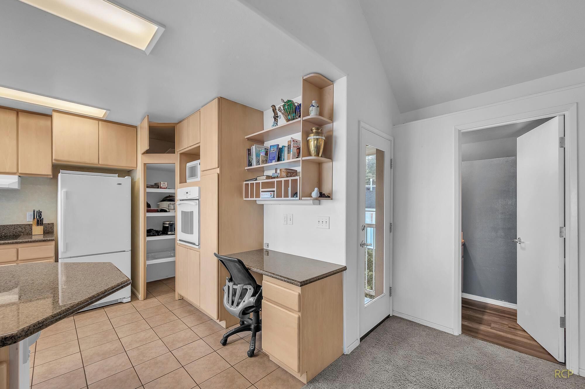 Uma cozinha compacta com eletrodomésticos embutidos, um pequeno espaço para refeições e um closet amplo.