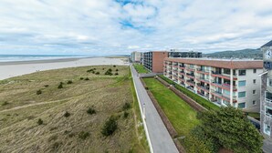 A coastal hotel with a long, narrow building adjacent to a beach. - Sweeping oceanfront views from this one bedroom condo right on the prom! (Seaside)