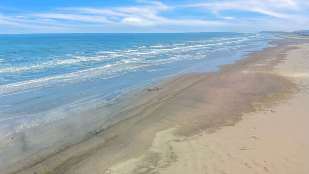 Una spiaggia con cieli sereni e onde calme.