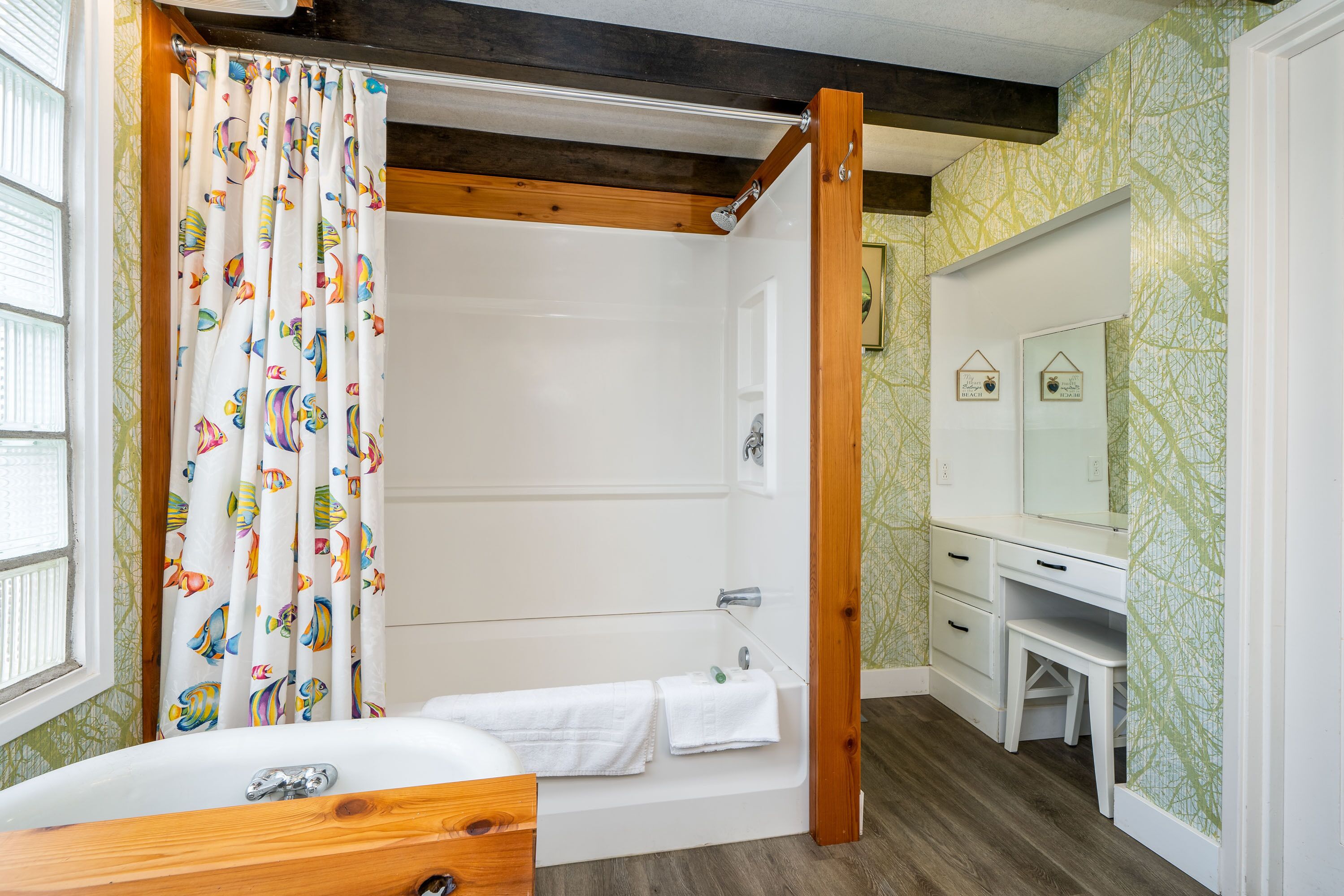 Une salle de bain avec une baignoire, un rideau de douche et un meuble-lavabo avec un miroir.
