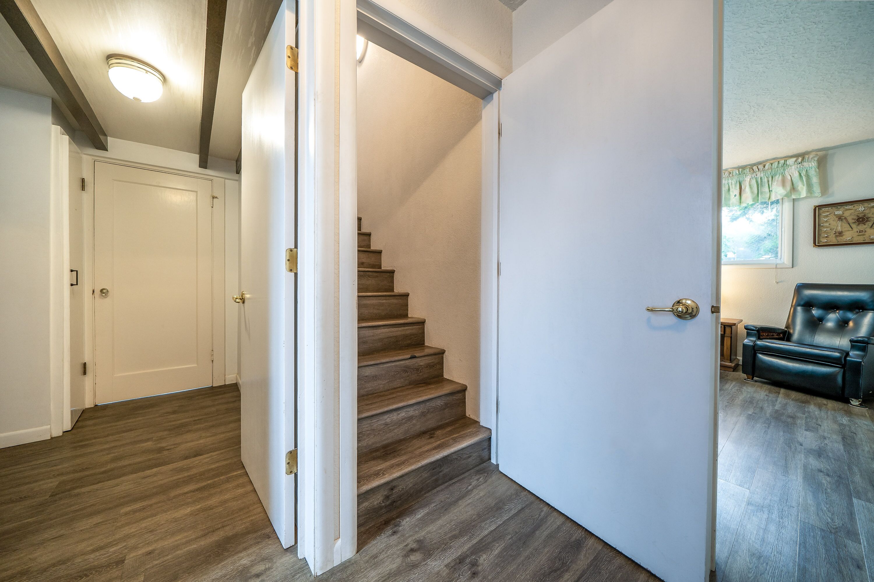 A staircase leading to a second floor with a wooden floor and white walls.