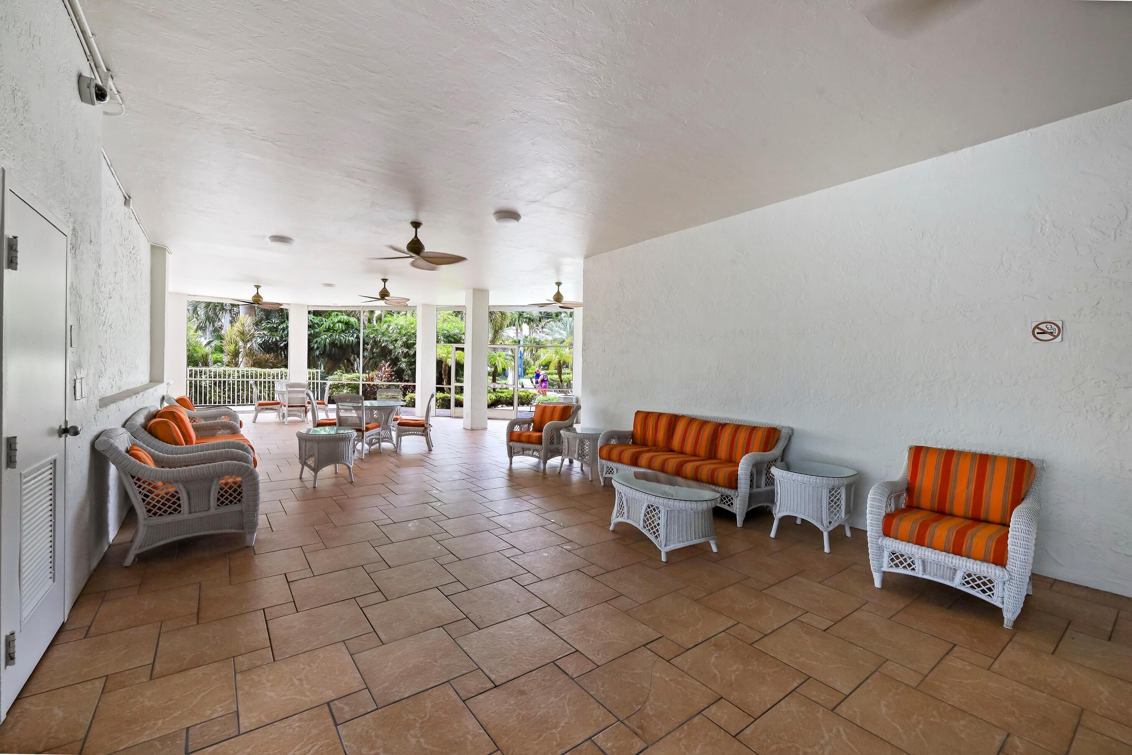A spacious indoor area with wicker furniture and tiled flooring.