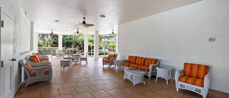 A spacious indoor area with wicker furniture and tiled flooring.
