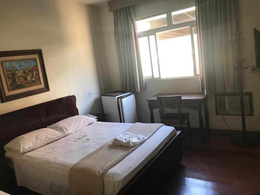 Ein Hotelzimmer mit einem Bett, einem Schreibtisch und einem Stuhl.