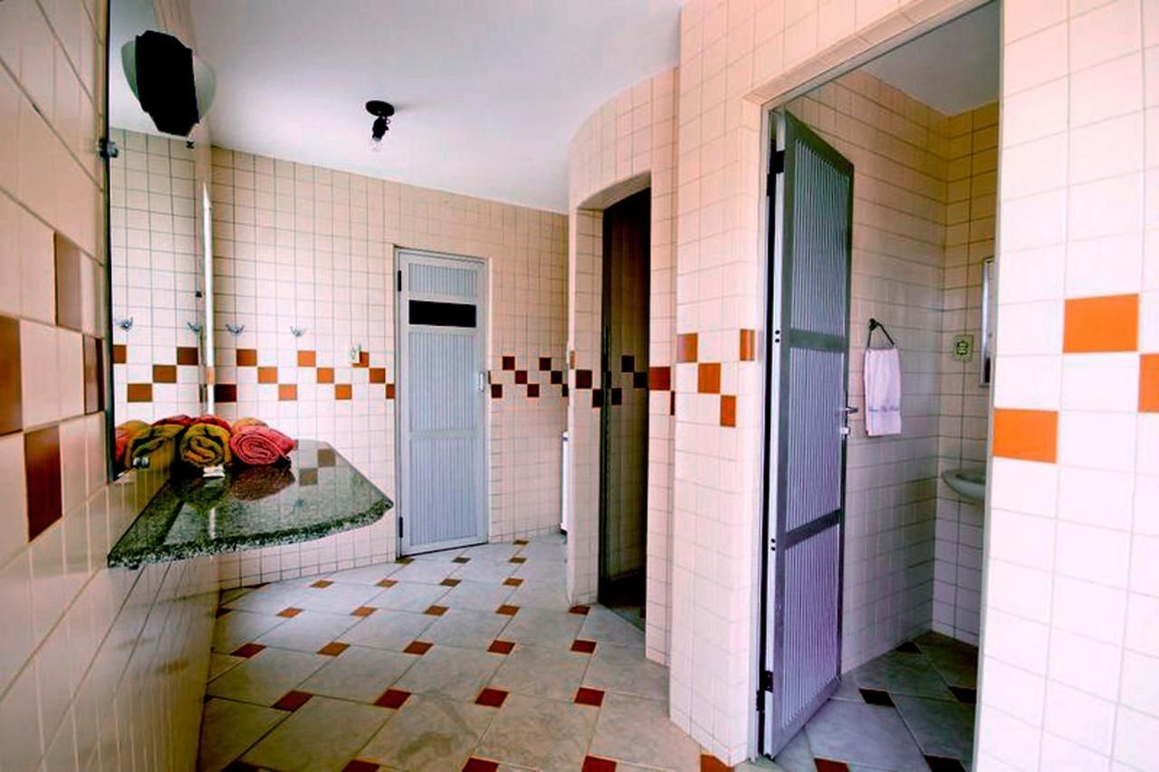 Ein Badezimmer mit gefliesten Wänden, einer Duschkabine und einem WC.